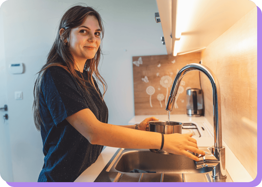 Woman at a sink filling a pot